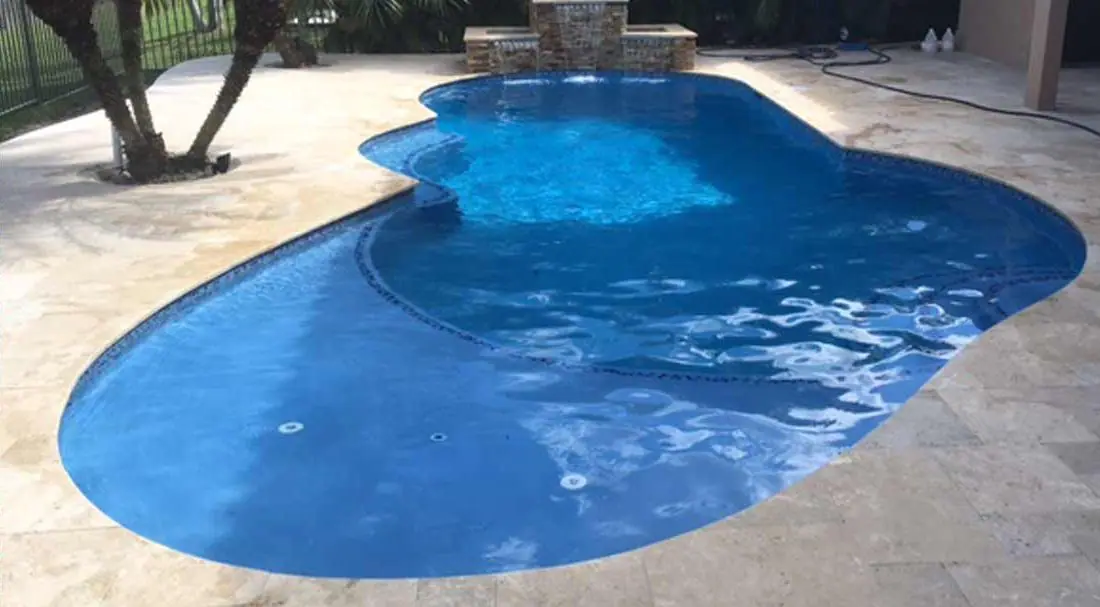 Pool with a Azure glass-bead finish, free-form pool with travertine deck and raised spa