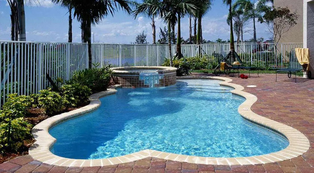 Pool with a Sky Blue glass-bead finish, free-form pool and spa with tropical landscaping