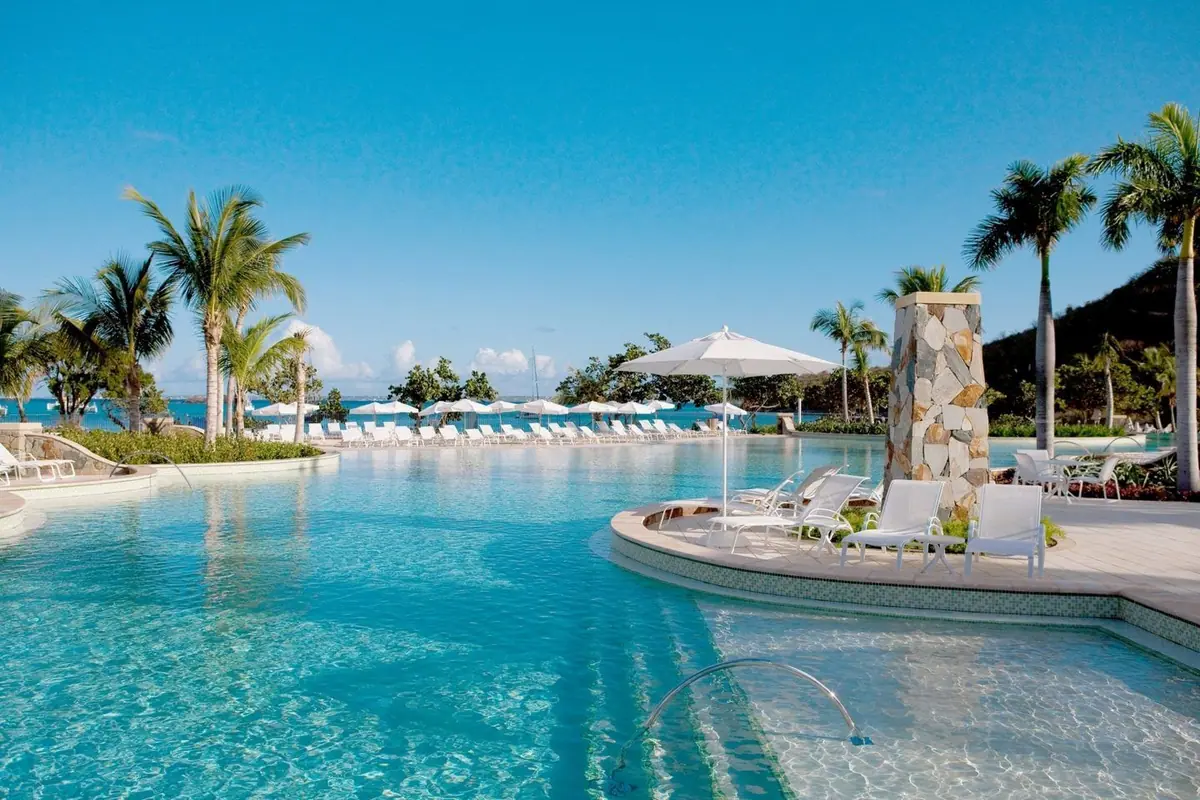 Large resort pool with a bright Classic white finish and palms