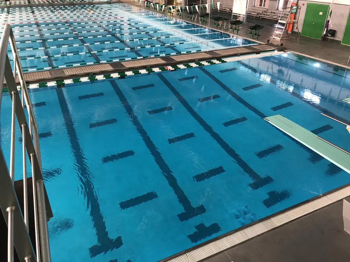 Indoor commercial lap pool with lane lines and blue finish