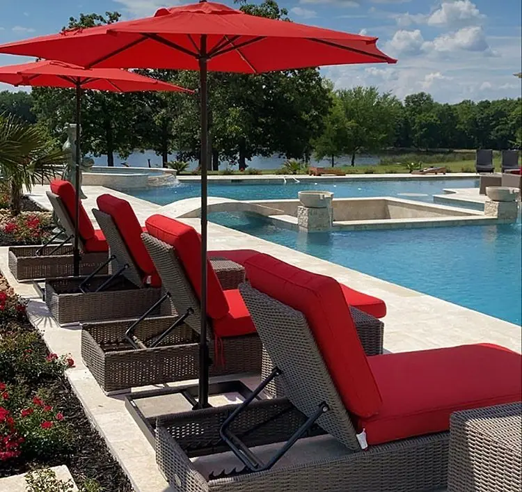 Resort-style pool with red umbrellas and lounge chairs on the deck