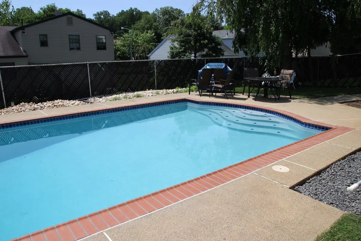 Rectangular pool with a bright white interior finish and red brick coping